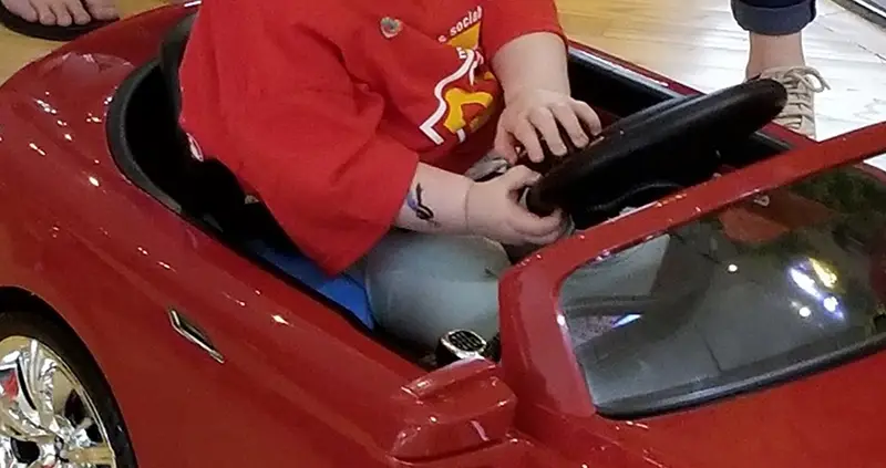 A young child operating a GoBabyGo car